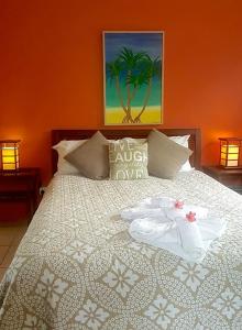 a bedroom with a large bed with an orange wall at Pandanus Holiday Apartments in Mission Beach