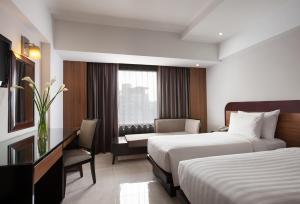 Postel nebo postele na pokoji v ubytování Hotel Santika Premiere Semarang