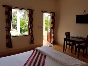 a bedroom with a bed and a table and a window at Herbal Hotel & Spa in Mui Ne