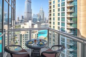 d'une table et de chaises sur un balcon avec vue sur la ville. dans l'établissement Dream Inn Apartments - Burj Residences Burj Khalifa View, à Dubaï