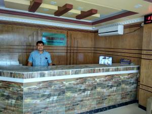 a man standing behind a bar in a restaurant at Hotel Quality Home in Cox's Bazar