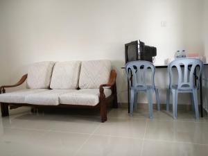 a living room with a couch and two chairs at Harum Manis Country House in Kangar