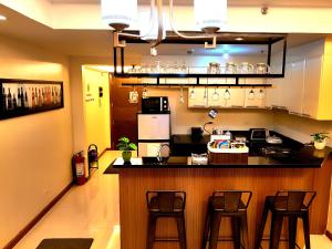 - une cuisine avec un comptoir et des tabourets dans une pièce dans l'établissement Luckycat Homestay, à Manille