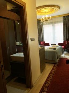 y baño con cama, lavabo y espejo. en Borancik Suites, en Estambul