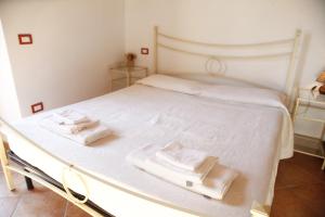białe łóżko z dwoma białymi ręcznikami w obiekcie Agriturismo Da Nonna Argia w mieście Massa e Cozzile
