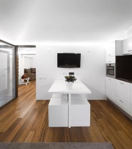 cocina blanca con mesa blanca y TV en Pedras Salgadas Spa & Nature Park, en Pedras Salgadas