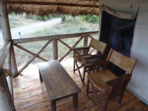 a group of chairs and a table on a porch at Roika Tarangire Tented Lodge in Kwa Kuchinia