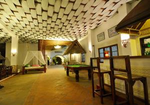 a living room with a pool table and a ceiling at Kilifi Bay Beach Resort in Kilifi