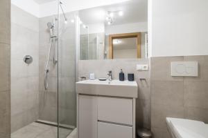 弗拉紹的住宿－Fischis Alpen Appartements，白色的浴室设有水槽和淋浴。