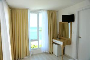ケメルにあるOlimpos Beach Hotel by RRH&Rの大きな窓、デスク、鏡が備わる客室です。
