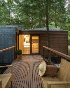 une terrasse en bois avec deux chaises et une maison dans l'établissement Pedras Salgadas Spa & Nature Park, à Pedras Salgadas