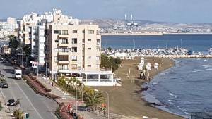 a view of a beach with a building and the ocean at Stadem Studios in Larnaca