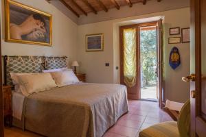 a bedroom with a bed and a sliding glass door at Agriturismo Borghetto Il Montino in Rapolano Terme