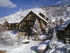 eine Ski-Lodge mit Auto im Schnee in der Unterkunft Hôtel Résidence Les Colchiques in Le Monêtier-les-Bains