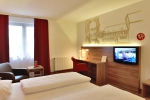 ACHAT Hotel Wetzlar في فيتسلار: غرفه فندقيه سرير وتلفزيون