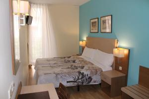 a bedroom with a bed and a table and a window at Hotel Mirador Puerta del Sol in Madrid