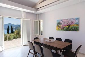 uma sala de jantar com uma mesa e uma grande janela em Villa Giovannina em Perama