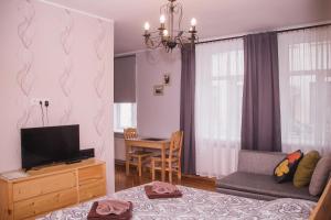 a living room with a couch and a television and a table at Ventspils Centra Apartamenti in Ventspils