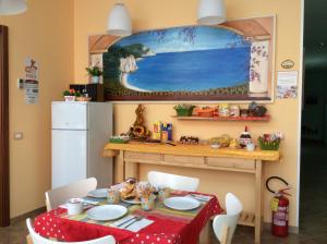 uma sala de jantar com uma mesa e um frigorífico em Locanda Del Picchio em Loreto