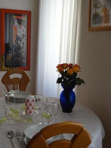 einen Tisch mit einer blauen Vase mit Blumen darauf in der Unterkunft Your Home In Vienna in Wien