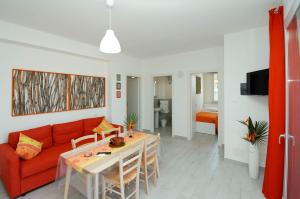 sala de estar con sofá rojo y mesa en Villa Barbara...a 100 passi dal mare!!!!, en Lascari