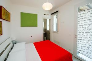 ラスカリにあるVilla Barbara...a 100 passi dal mare!!!!の白いベッドルーム(赤いベッド1台、窓付)