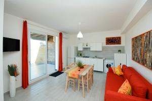 sala de estar con sofá rojo y mesa en Villa Barbara...a 100 passi dal mare!!!!, en Lascari