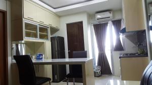 uma cozinha com mesa e cadeiras num quarto em Educity Apartment Princeton - Jusuf em Surabaia