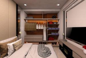 Educity Apartment Princeton - Jusuf في سورابايا: غرفة مع تلفزيون وخزانة مع شماعات