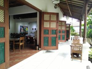 a room with doors and a table and chairs at nDalem Natan Royal Heritage in Yogyakarta