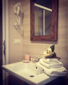 a bathroom with a sink and a mirror and towels at B&B Parini in Cassino