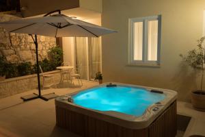 a jacuzzi tub in a room with an umbrella at Dida moj in Senj