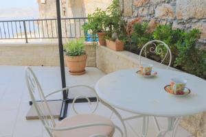 a white table and chairs on a balcony with plants at Dida moj in Senj