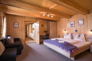 a bedroom with a large bed and a couch at Ferienwohnungen Rieder in Gerlos