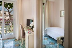 a bedroom with a bed and a view of a balcony at Hotel Continental Ischia in Ischia