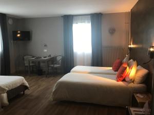 a hotel room with two beds and a table at Hôtel Panorama in Munster