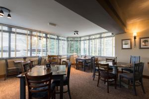 a restaurant with tables and chairs and windows at Owl, Hambleton by Marston's Inns in Selby