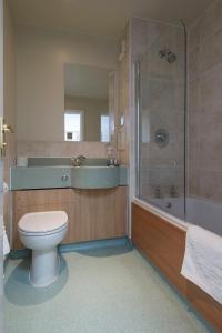 a bathroom with a toilet and a shower and a tub at Owl, Hambleton by Marston's Inns in Selby