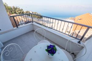 a table and chairs on a balcony with a view of the ocean at Dida moj in Senj