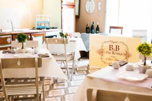 um restaurante com mesas e cadeiras brancas e um cartaz que diz BC Wine Novato em B&B Via Roma em San Severo