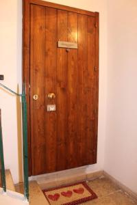 Una puerta de madera en una habitación con un cartel. en Villari 60, en Bari