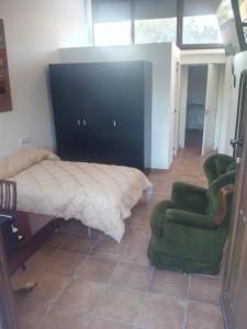 1 dormitorio con 1 cama y 2 sillas verdes en Villamercedes Estudio 3, en Salamanca