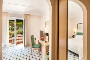 a hotel room with a bed and a desk with a computer at Hotel Continental Ischia in Ischia