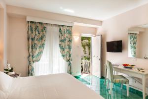 a bedroom with a bed and a desk and a window at Hotel Continental Ischia in Ischia