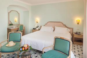 a hotel room with a bed and two chairs at Hotel Continental Ischia in Ischia