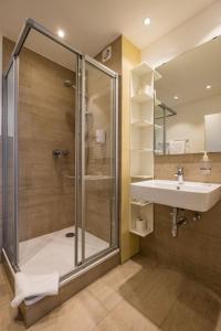 
a bathroom with a shower, sink, and toilet at Hotel Cityroom in Gelsenkirchen
