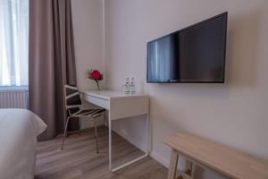 
a living room with a tv and a table at Hotel Cityroom in Gelsenkirchen
