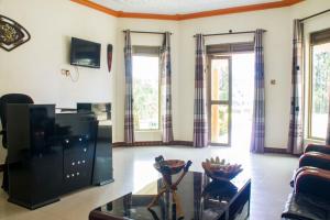 sala de estar con sofá y mesa en Rays Hotel en Mbarara