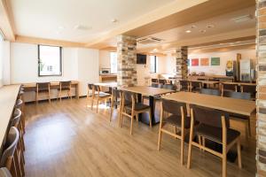 a dining room with wooden tables and chairs at Comfort Inn Niigata Kameda in Niigata