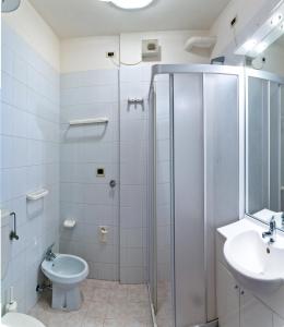 une salle de bains avec douche, toilettes et lavabo dans l'établissement Auriga del Sole, à Bibione